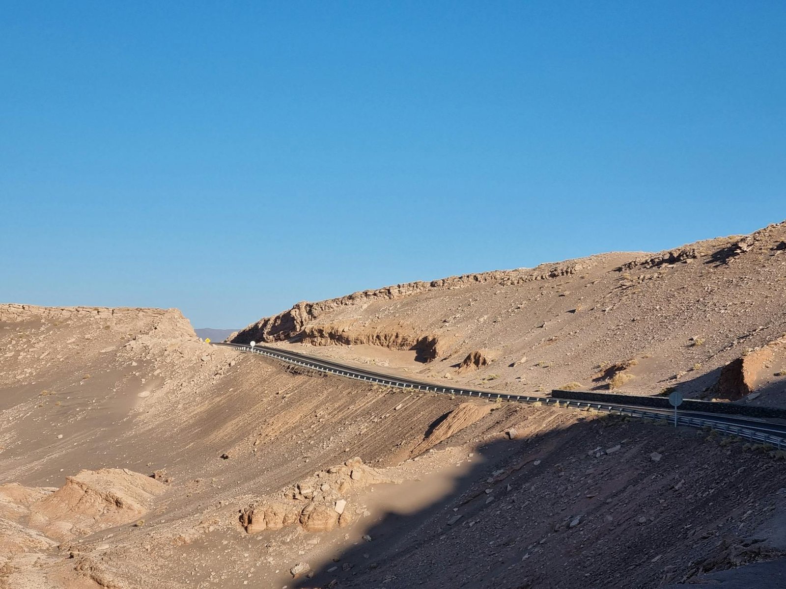 Route traversant les paysages arides de l'Atacama avant la frontière bolivienne