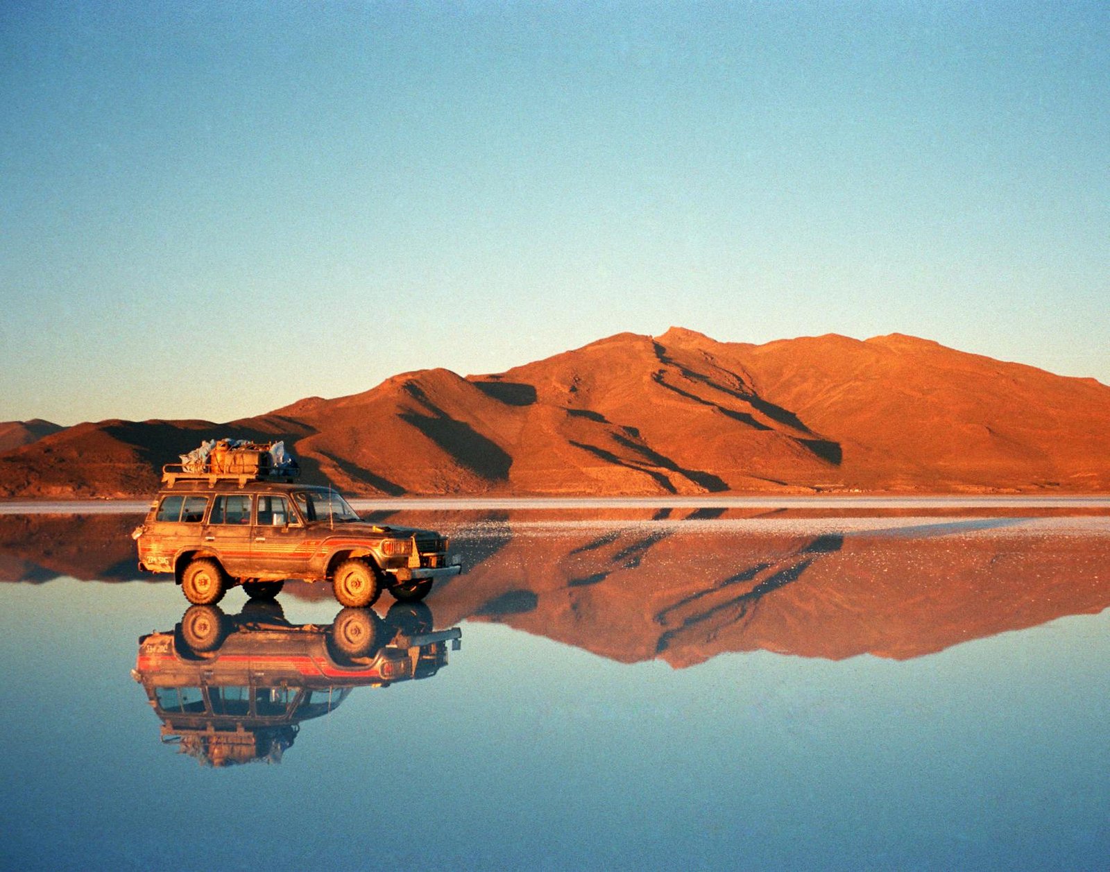 4x4 sur le Salar d'Uyuni au coucher du soleil après la traversée depuis San Pedro de Atacama