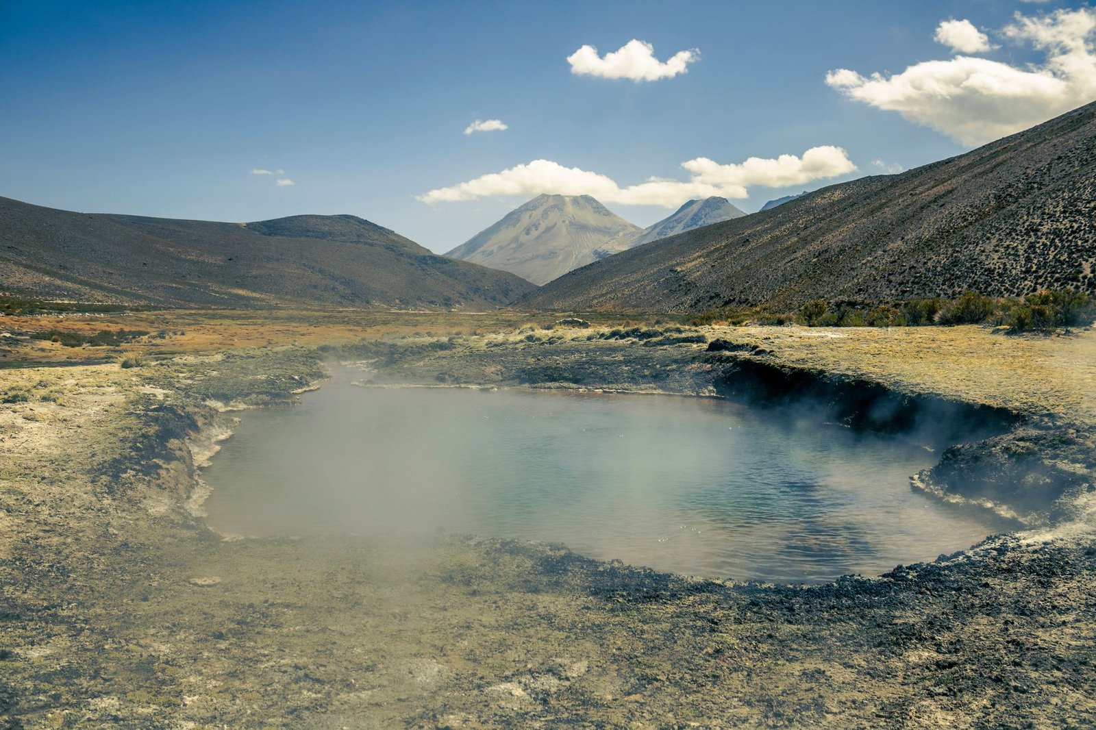 Bassin thermal de montagne dans un paysage andin rappelant les environs du Sajama