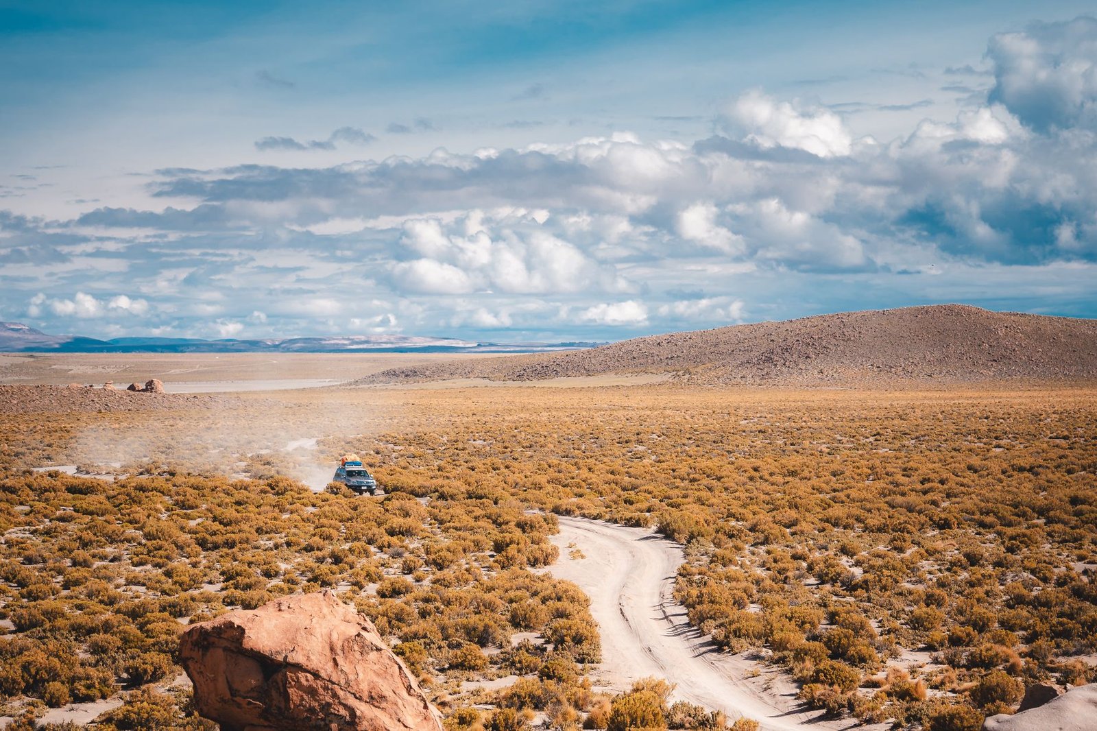 Véhicule sur une piste poussiéreuse de l’Altiplano bolivien